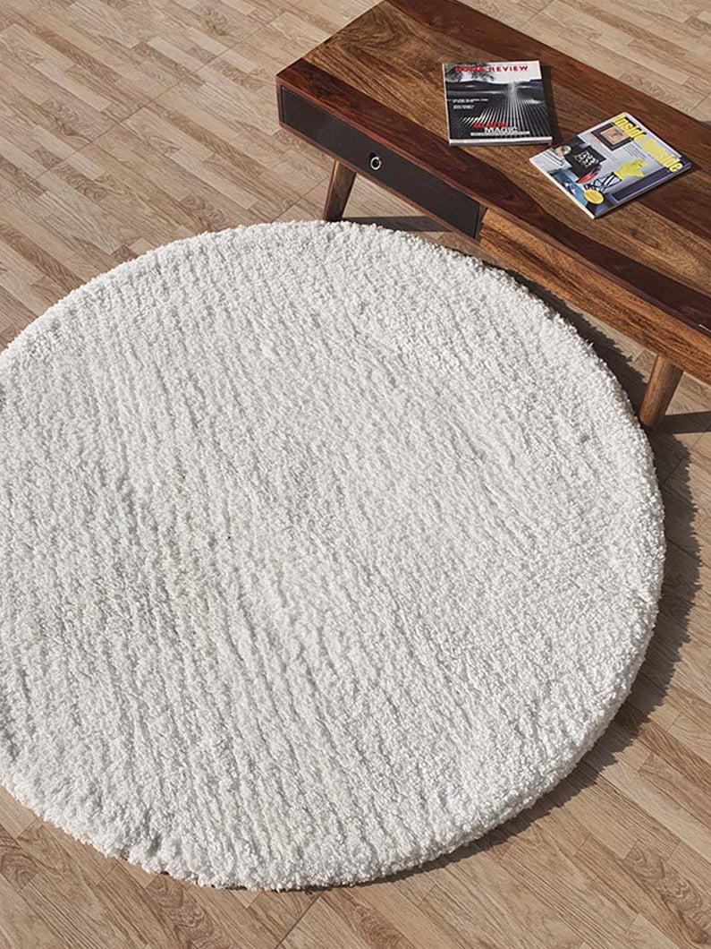 White round shaggy rug anchoring a living space, highlighting its ultra-soft plush texture and luxurious comfort.
