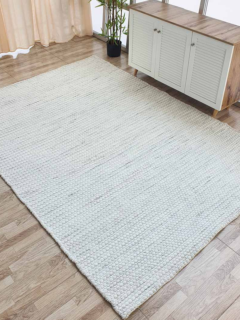 Side angle view of the rectangular PET woven rug in a living space, showcasing its long-lasting durability in a high-traffic area.