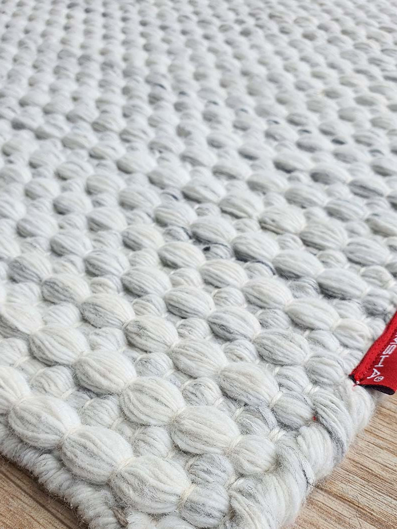 Side close-up highlighting the expert, meticulous weave and tight edge construction of the handmade area rug.