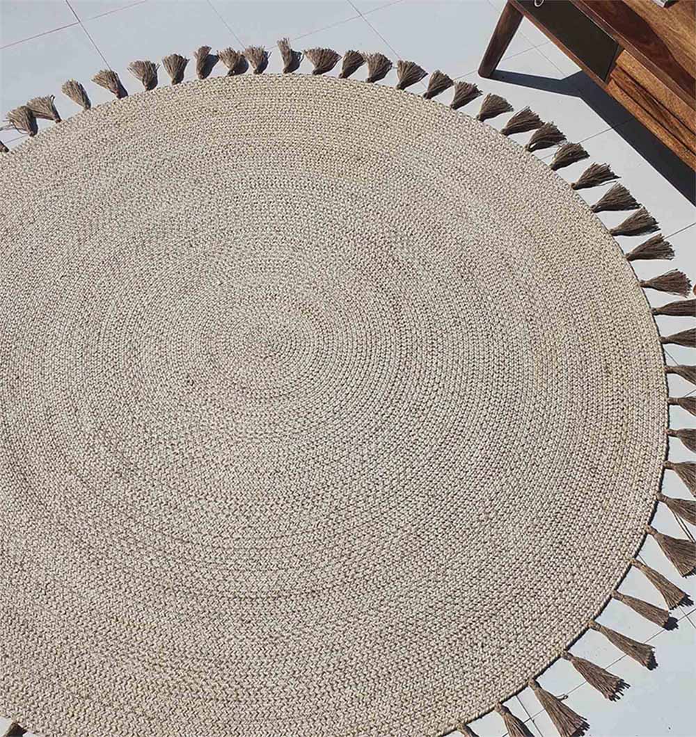 Circular natural jute rug in a living space, functioning as a hand-woven accent for floor protection and room definition.