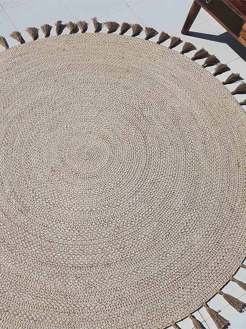 Circular natural jute rug in a living space, functioning as a hand-woven accent for floor protection and room definition.