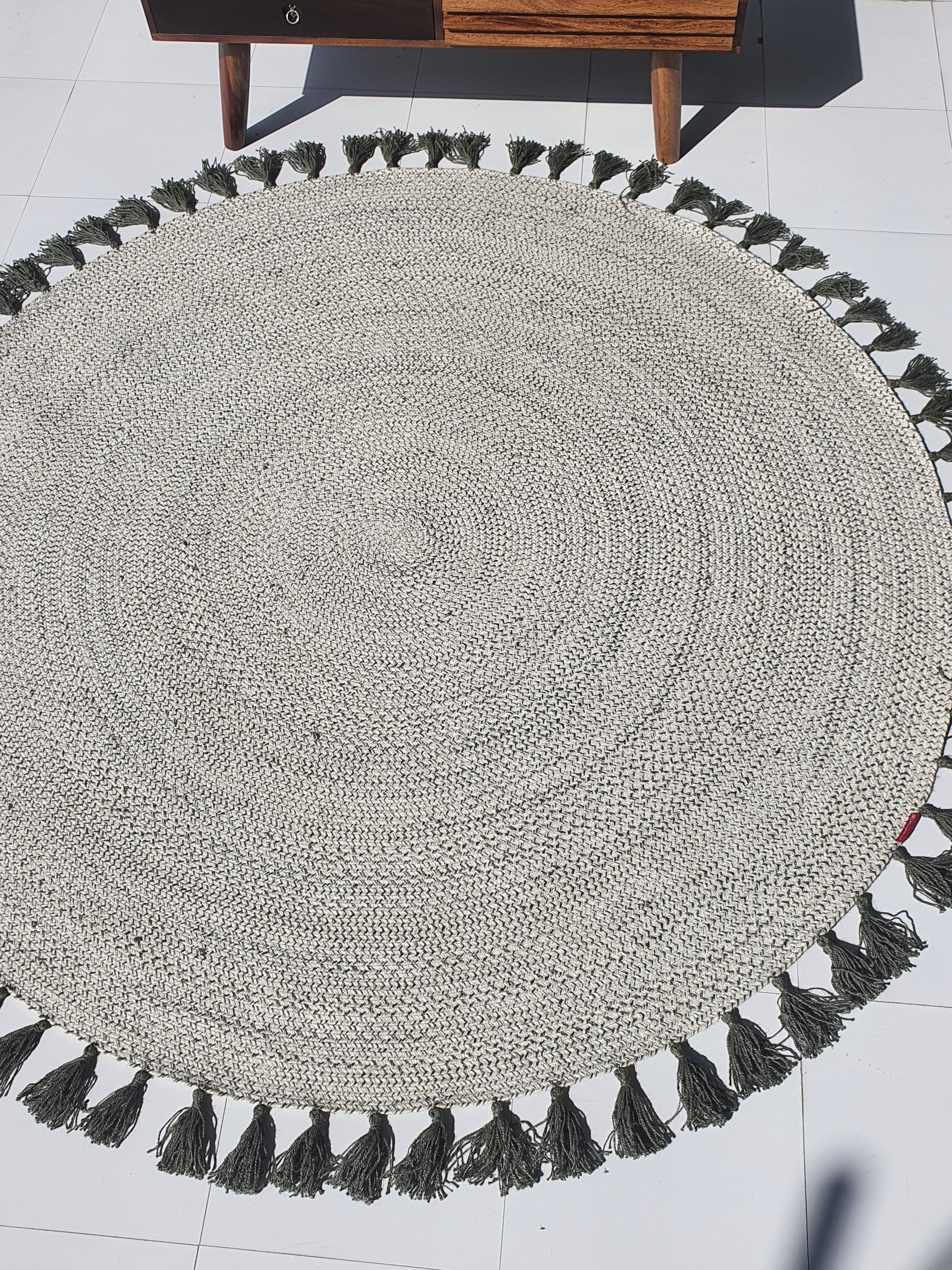 Jute round rug placed beneath a wooden table, highlighting its durability as a hard-wearing circular floor mat.