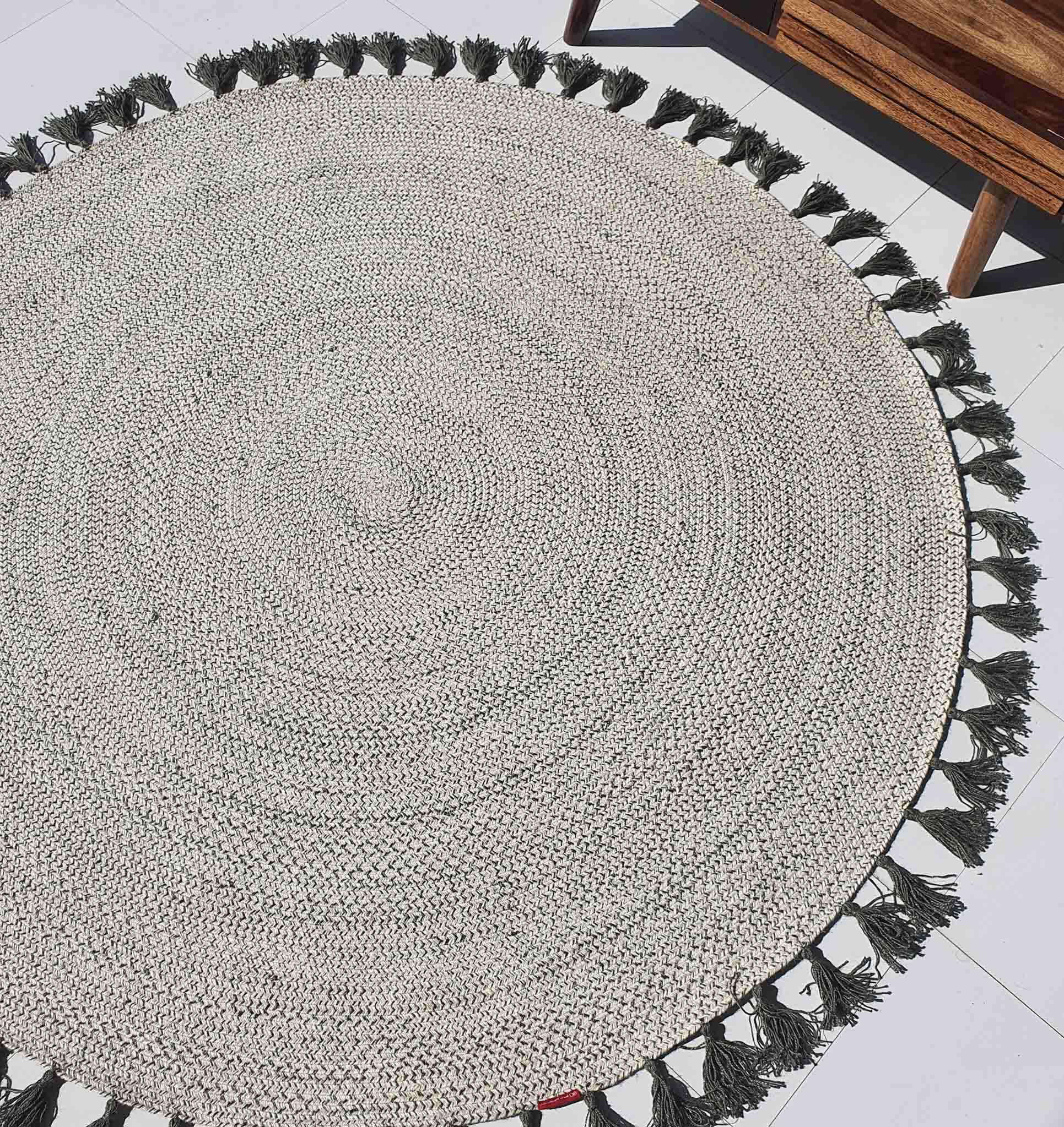 Circular jute braided rug in a living space, showcasing the 100% natural fiber material and sustainable construction.
