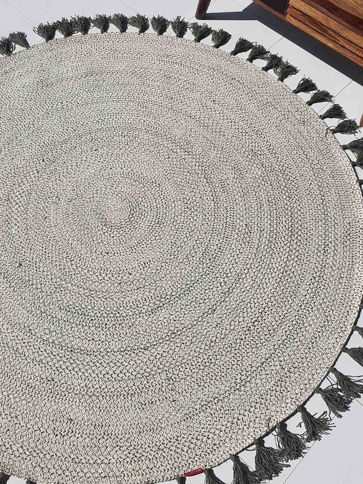 Circular jute braided rug in a living space, showcasing the 100% natural fiber material and sustainable construction.