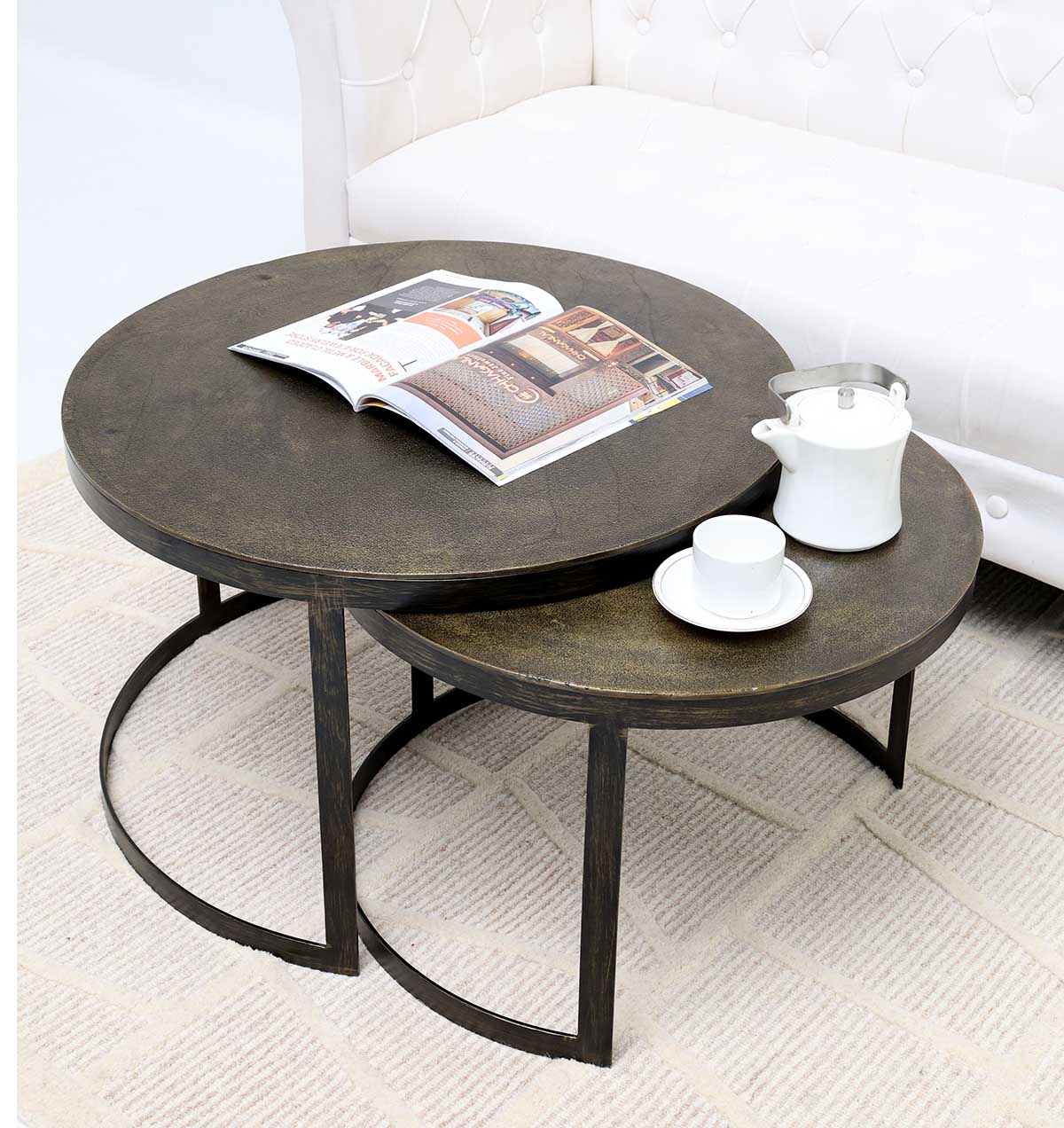 Nesting coffee table set with round wooden tops and sleek metal frames.