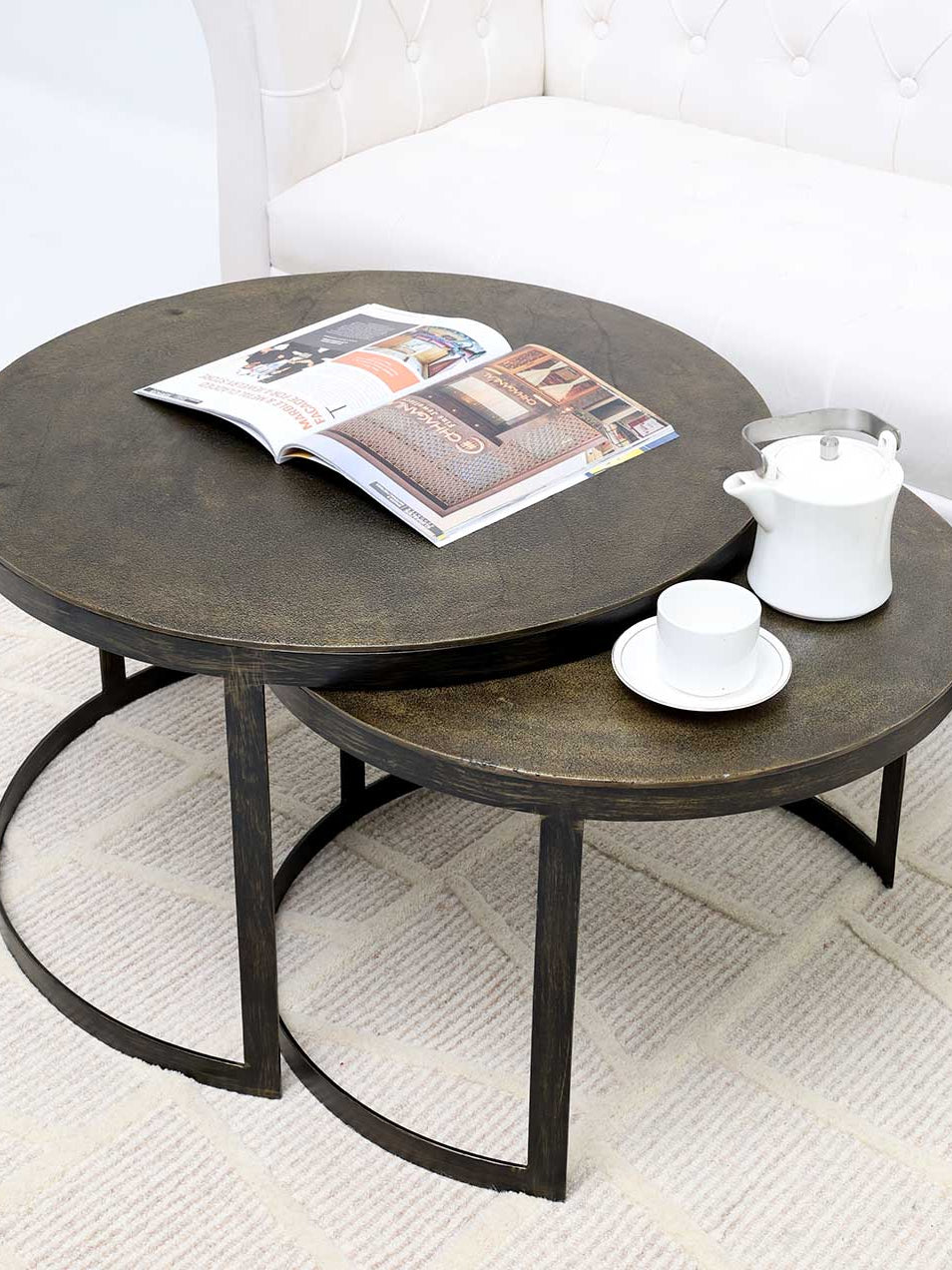 Nesting coffee table set with round wooden tops and sleek metal frames.