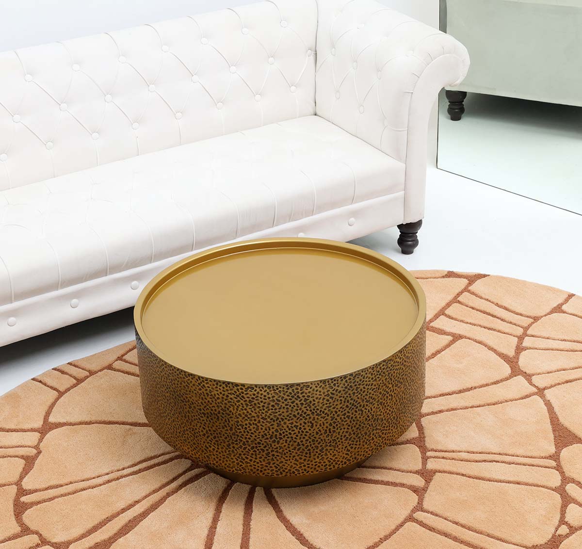 Statement furniture piece with circular iron top and shimmering gold finish.