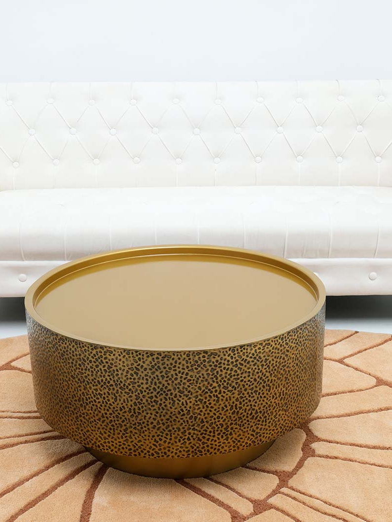 Sculptural accent table with luxe gold surface and intricate texture on iron base.