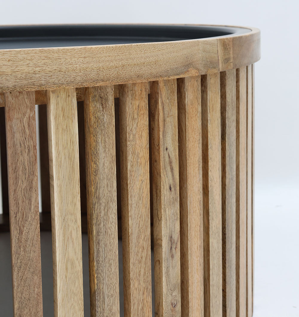 Minimalist coffee table with round wooden top and industrial-style iron support.