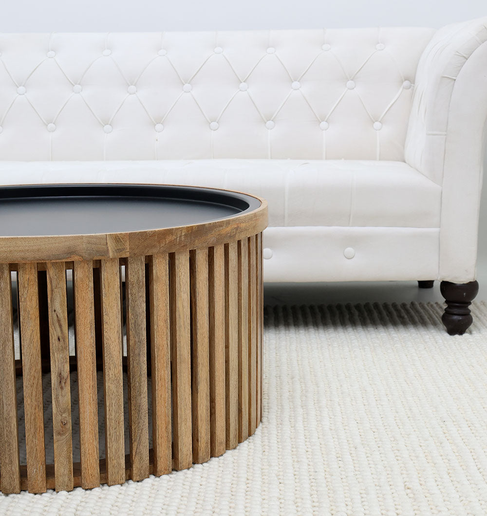 Round coffee table with slatted wood top and iron base, perfect for modern living rooms.