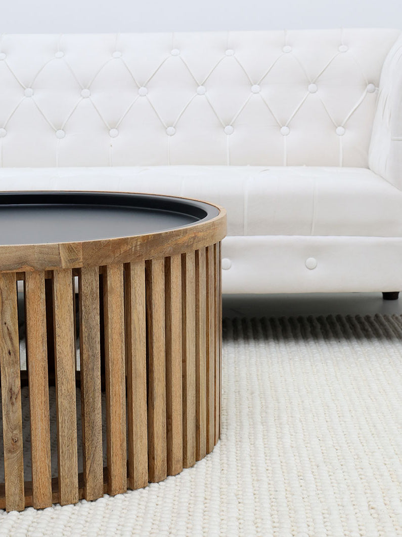Round coffee table with slatted wood top and iron base, perfect for modern living rooms.