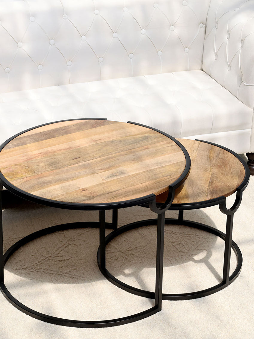 Modern nesting coffee table set with round wooden tops and sleek metal frames.