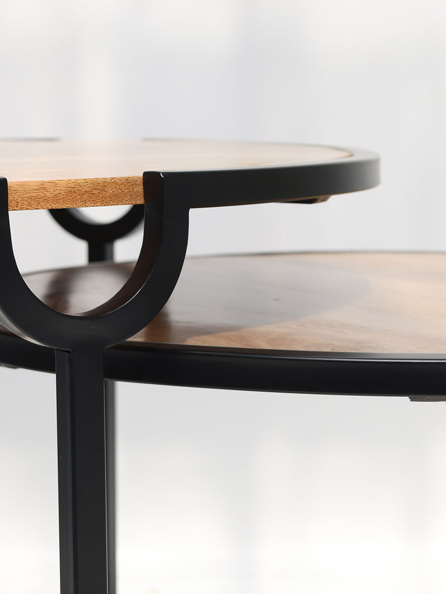 Contemporary round coffee tables with wood surfaces and black metal bases.