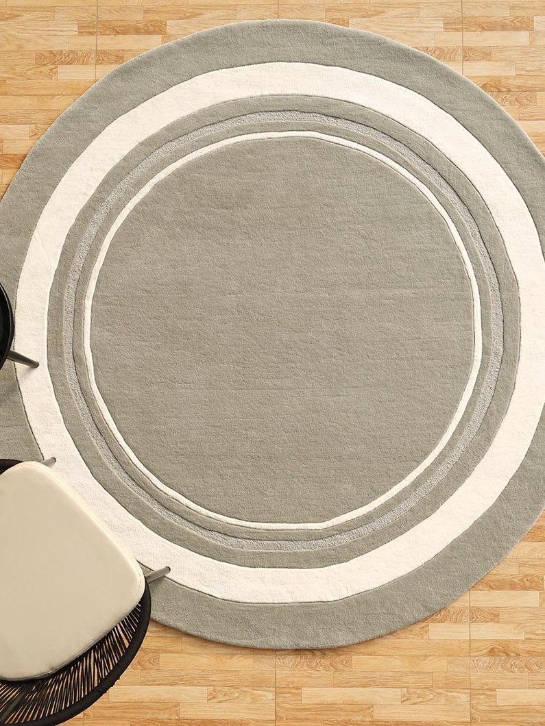Round handmade area rug in grey and white tones, providing a timeless, versatile look for an elegant interior.