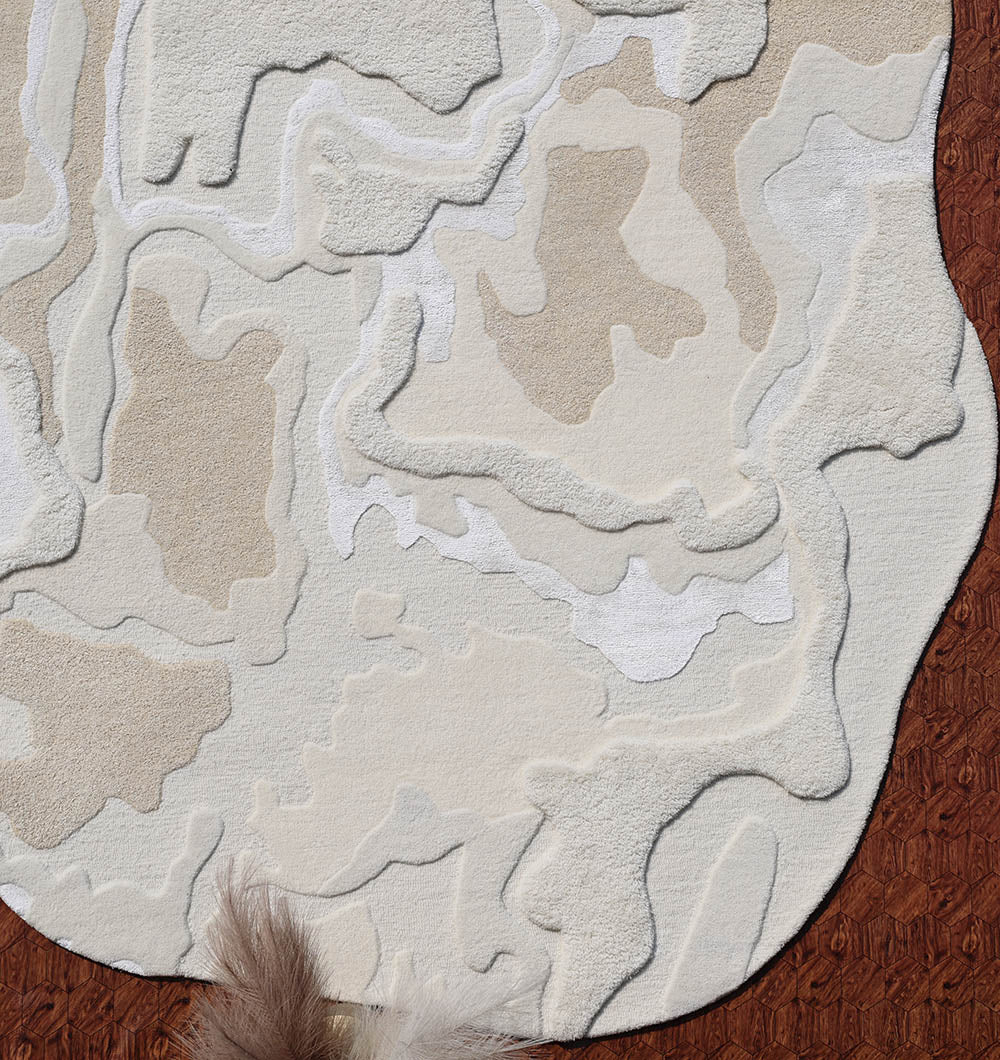 Close-up of the shaped rug's edge where it meets the floor, showing its elegant finish.