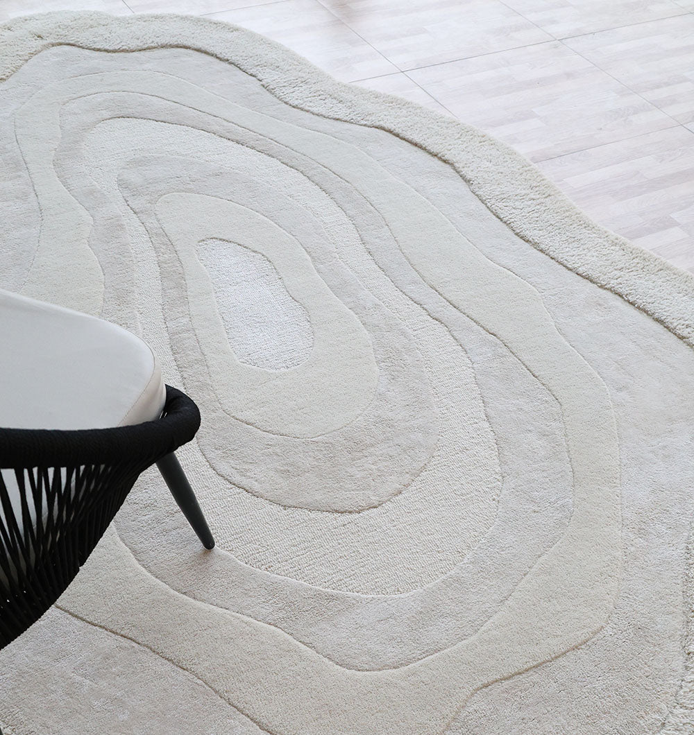 Angled view of the rug with a chair, emphasizing the superior quality and soft feel provided by the natural fibers.