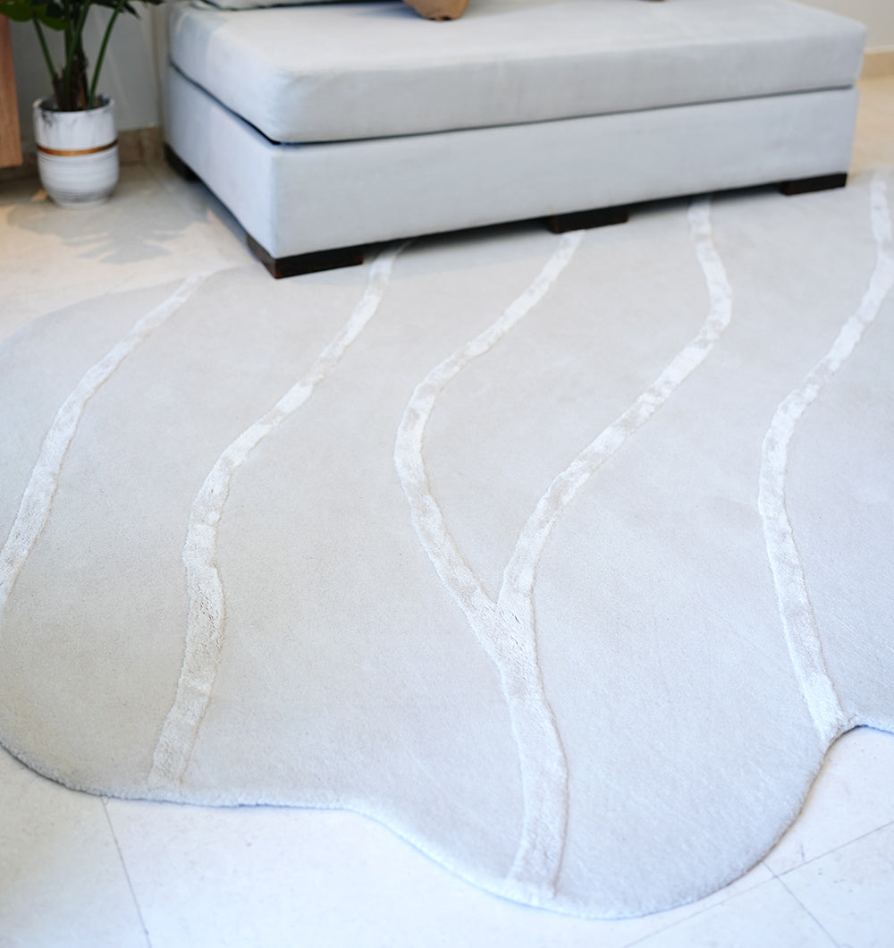 Unique shaped natural white rug accenting a living room, showcasing its aesthetic sophistication and timeless elegance.