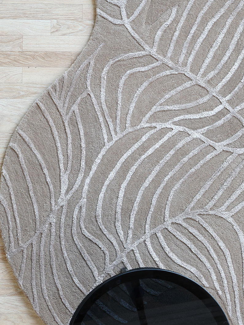 Top-down view of the shaped, natural white rug beneath a round table, providing a unique character to the dining area.
