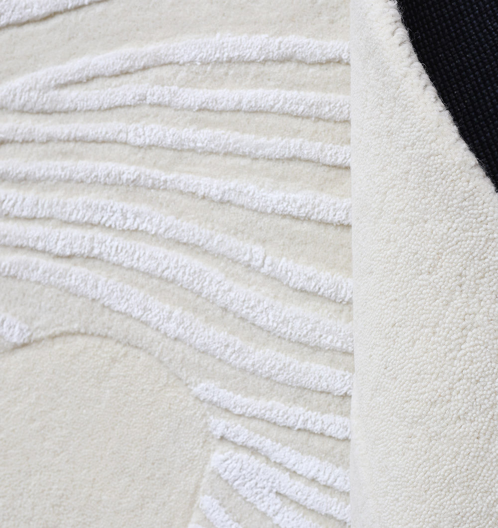 Detailed shot focusing on the textured leaf pattern design and aesthetic sophistication of the rug's surface.