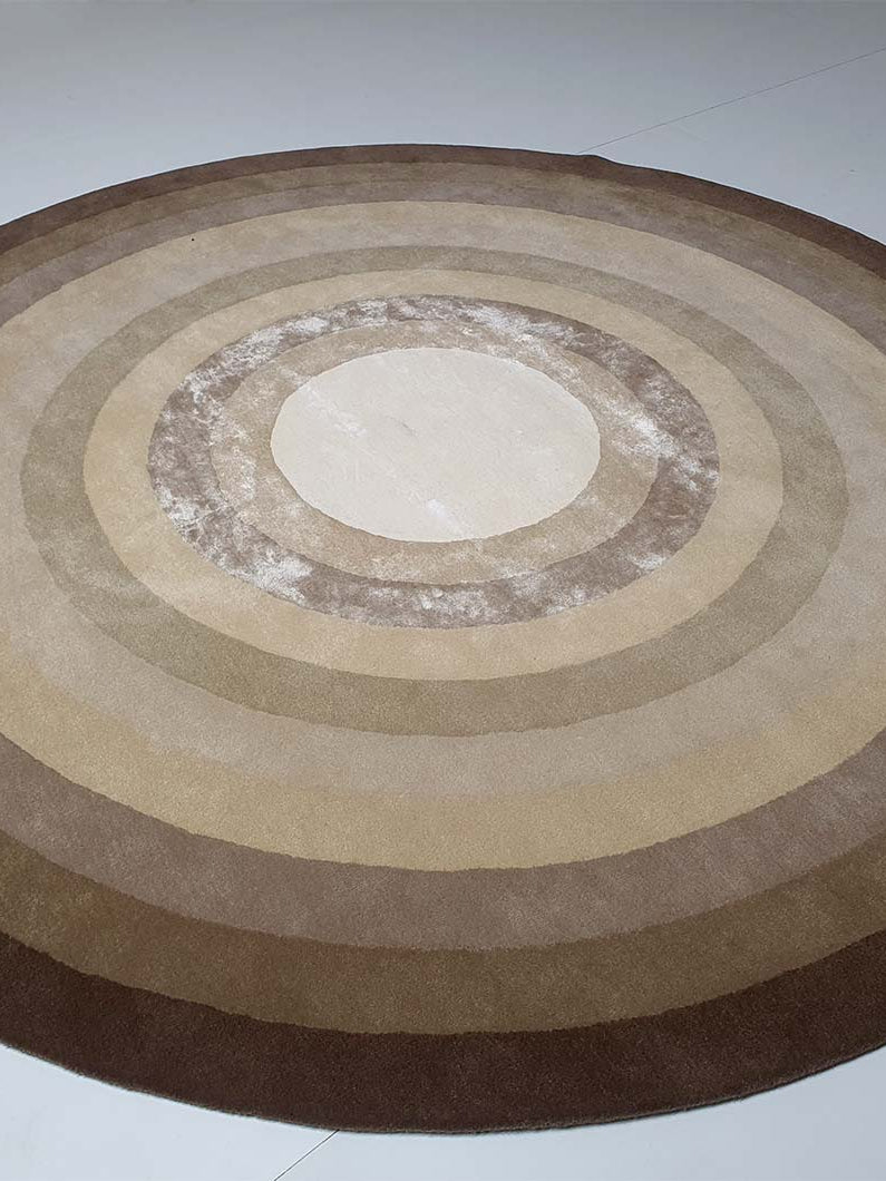 Side-angled view of the round rug, highlighting the dense pile height and the lustrous finish of the blended composition.