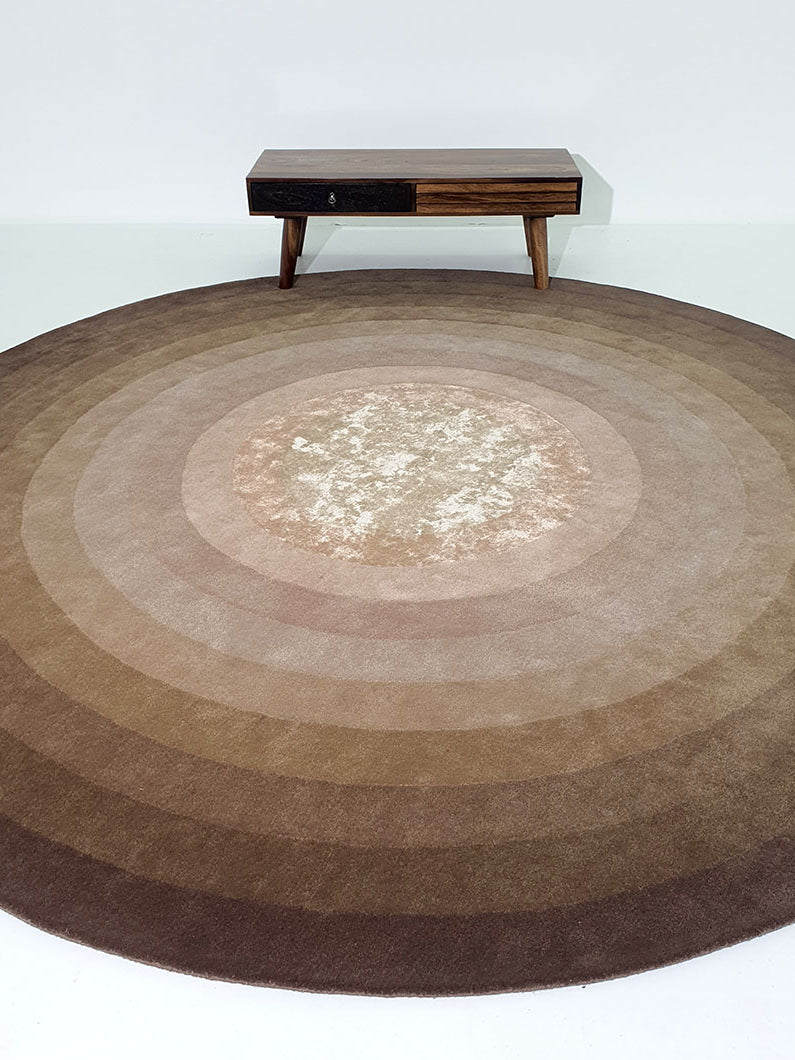 Oversized round rug placed in a dining room, emphasizing the resilient wool and durable weave for heavy use.