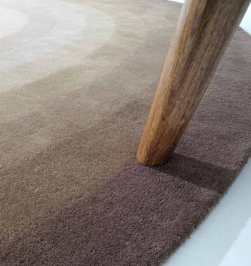 Close-up detailing the luxurious feel and plush underfoot quality of the multi-color wool blend surface.