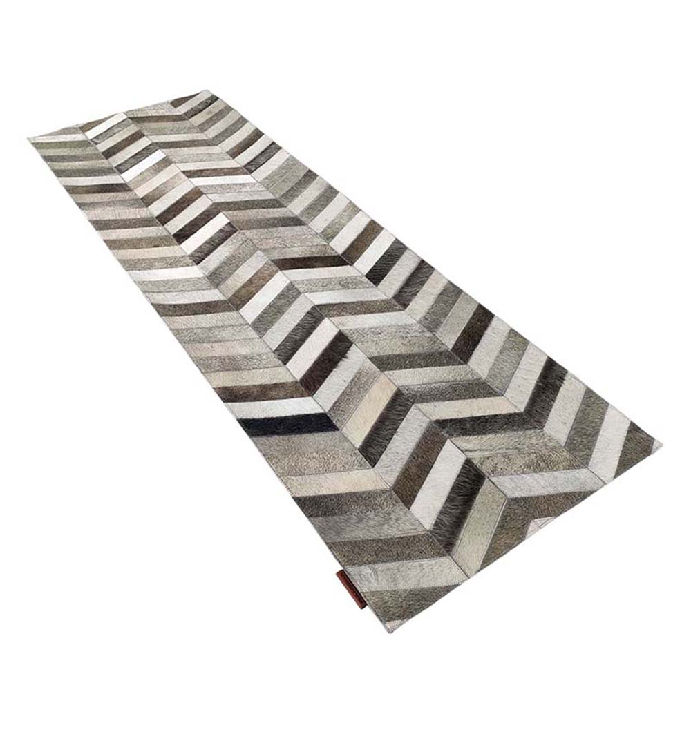 Side-angle view of handmade multi-colored leather rug LR-003 showcasing geometric patterns in a living room