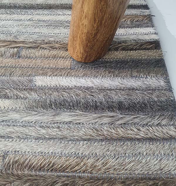 Close-up image detailing the looped weave structure and custom crafted stitching of the leather and wool materials.