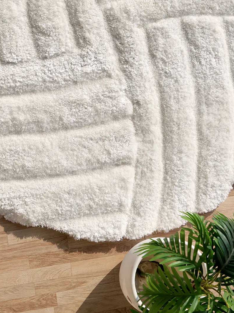Side close-up highlighting the dense plush texture and soft $80\%$ polyester blend of the round luxury shaggy rug.