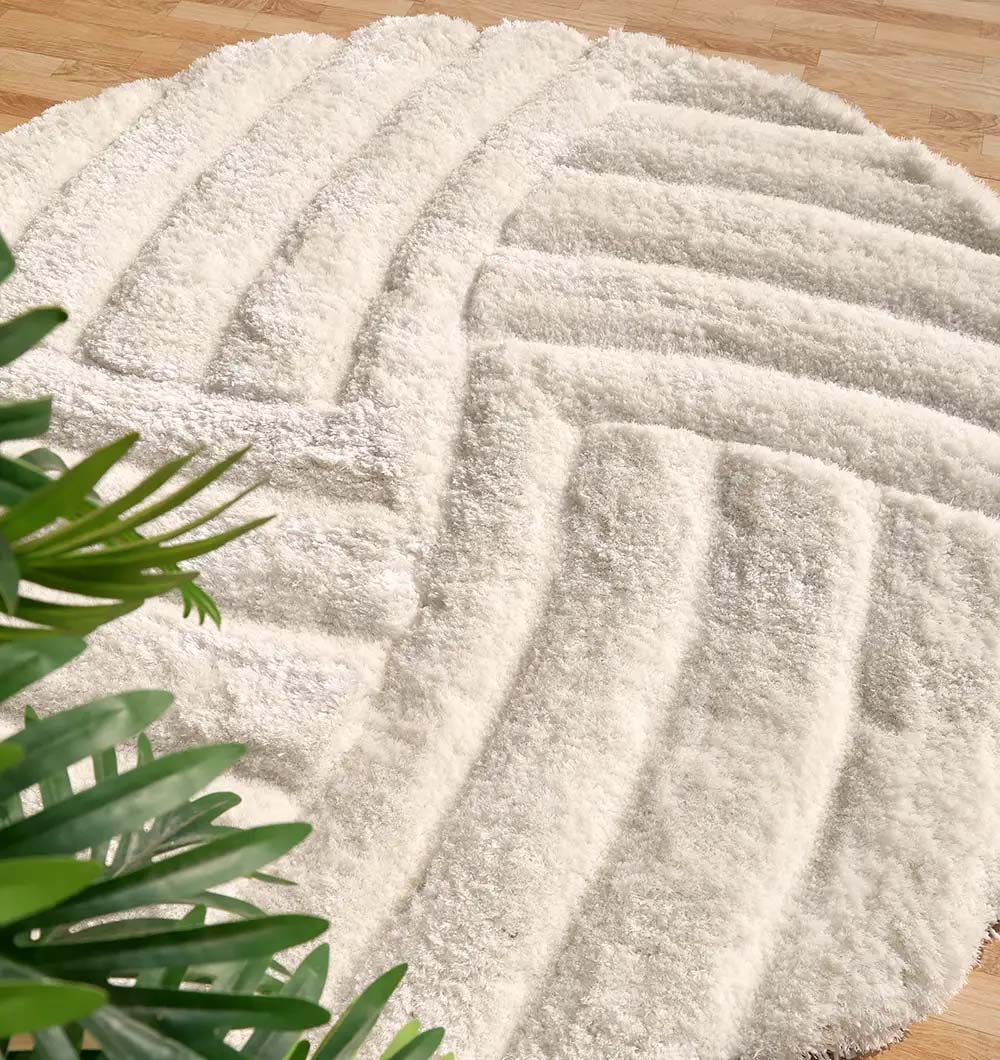 Side angle of the round shaggy rug, providing a cozy and inviting atmosphere with its thick, warm texture.