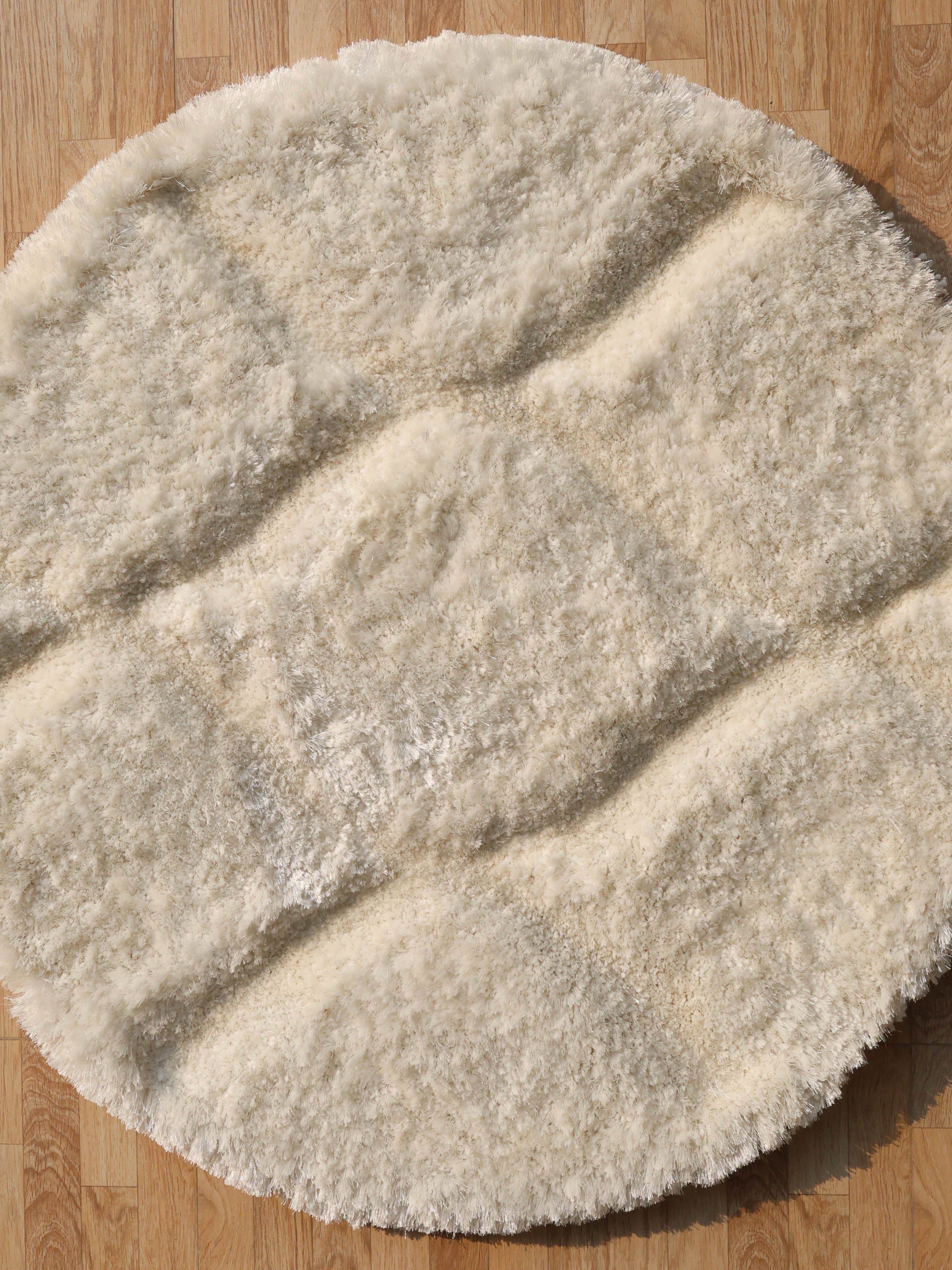 Overhead view showcasing the full round shape and timeless elegance of the white shaggy carpet.