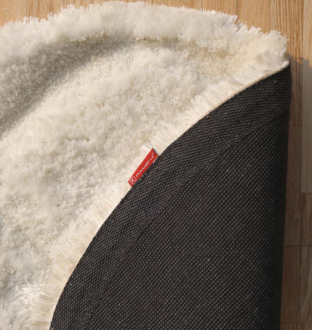 Backside of the cream round luxury shaggy rug, confirming the durable backing and expert handmade construction.