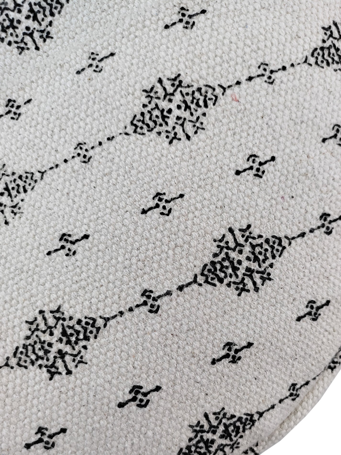 Detailed view of a black and white woven cotton pouf featuring fringe edges, ideal for chic and contemporary home décor.