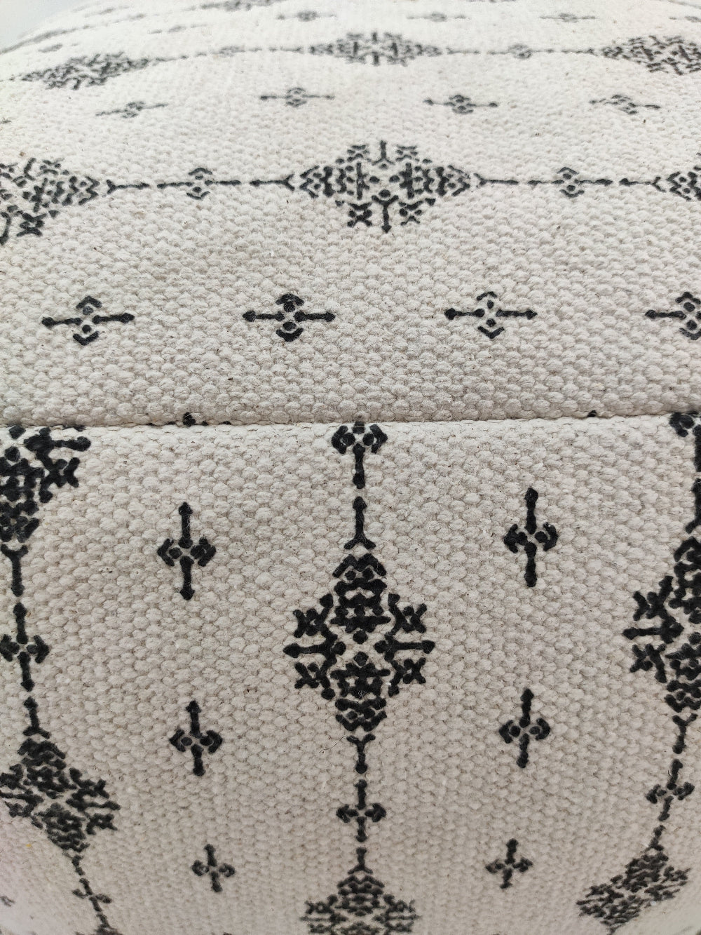 Modern black and white cotton pouf with soft fringe detailing, ideal for stylish and comfortable home decor.