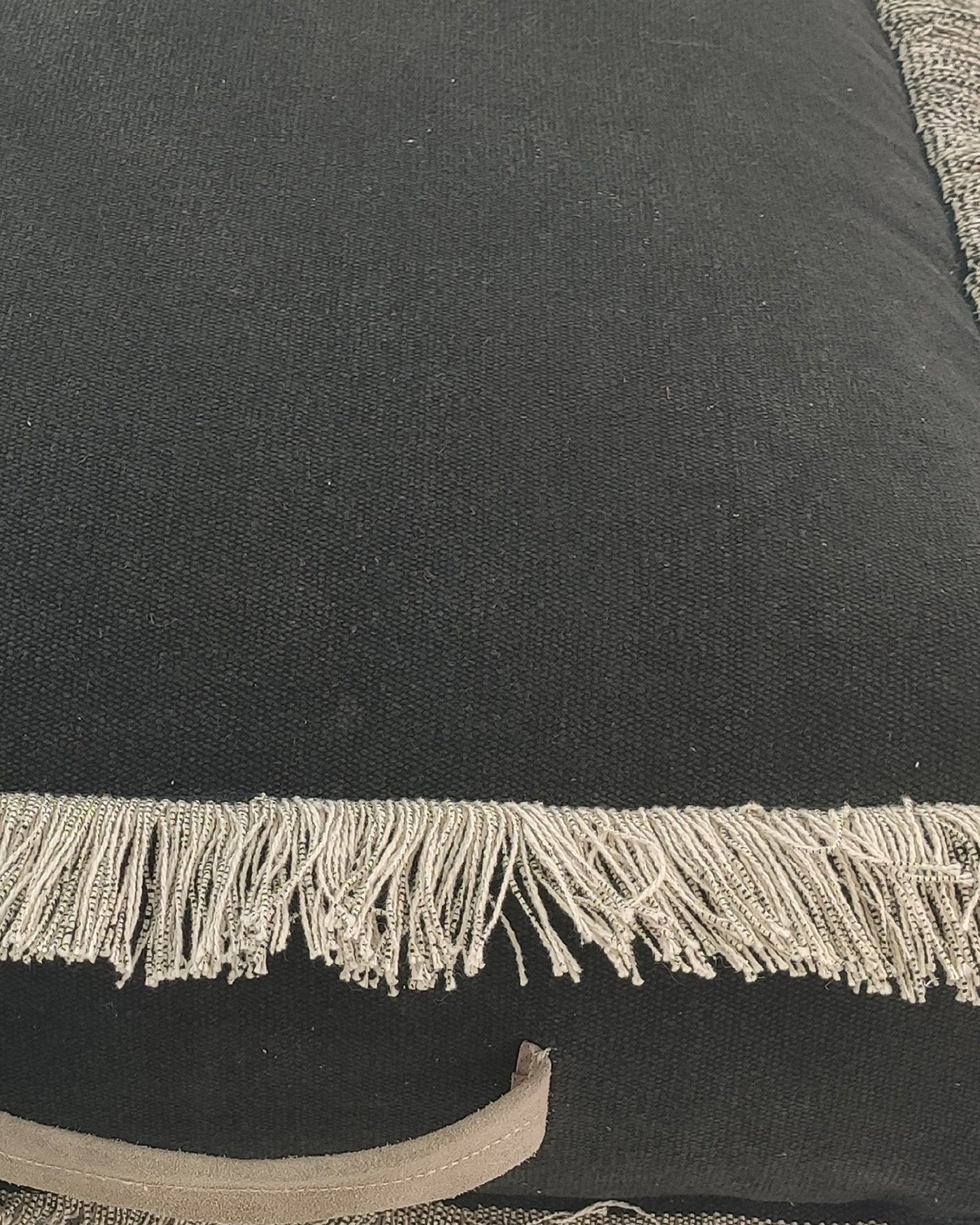 Detailed shot showcasing the rich black cotton weave and premium leather handle craftsmanship of the handmade pouf.