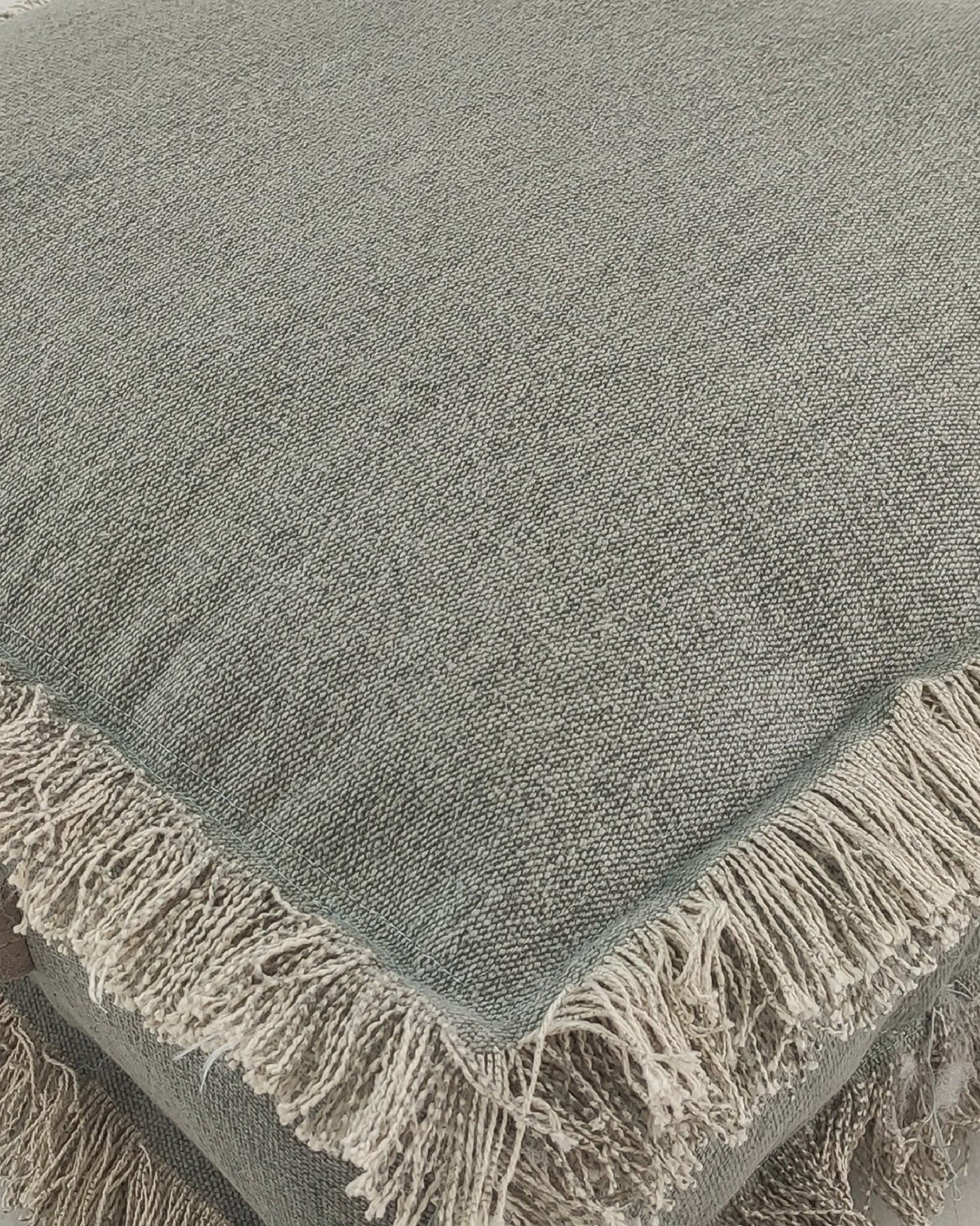 Detailed shot showing the fine cotton weave and premium leather handle of the grey pouf.