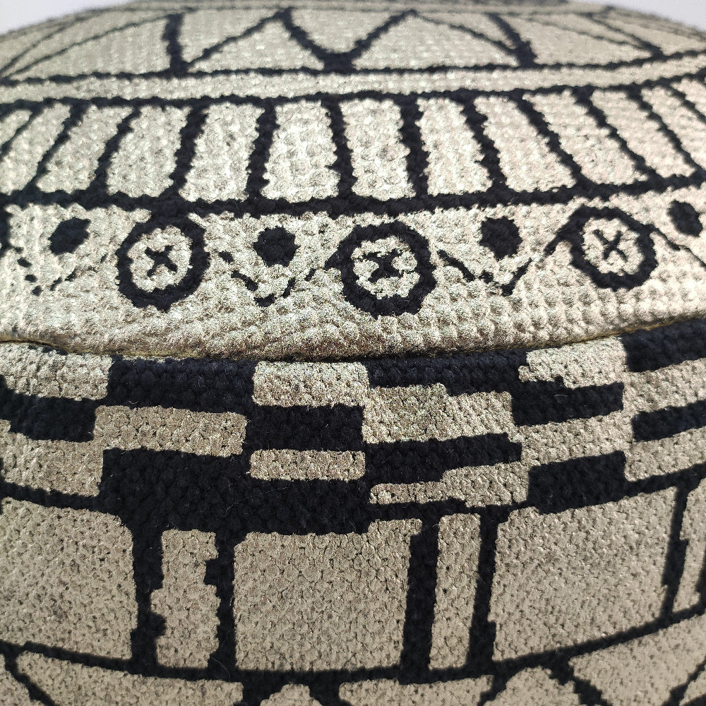 Close-up view of black and gold cotton pouf highlighting its textured fabric and premium leather handle.