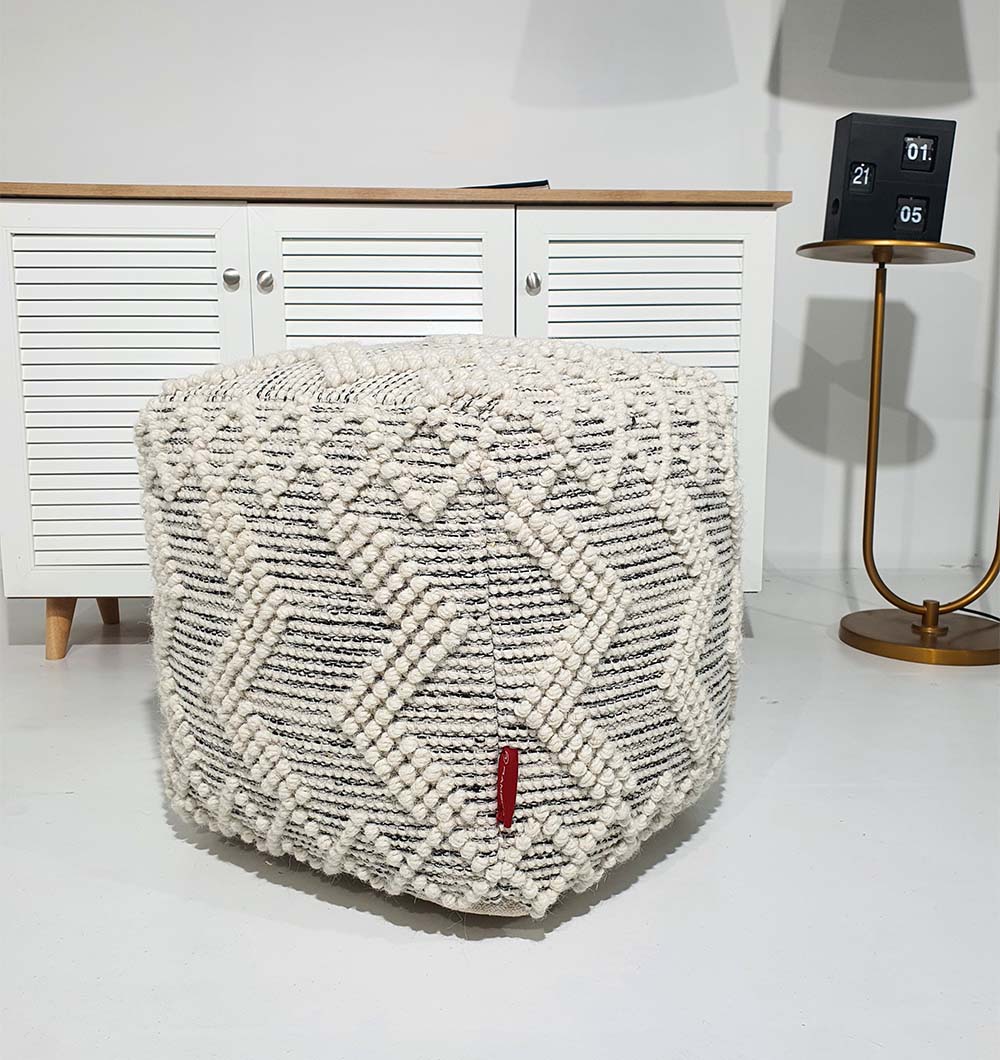 Square handmade pouf crafted from 90% wool and 10% cotton with soft natural tones for elegant interiors