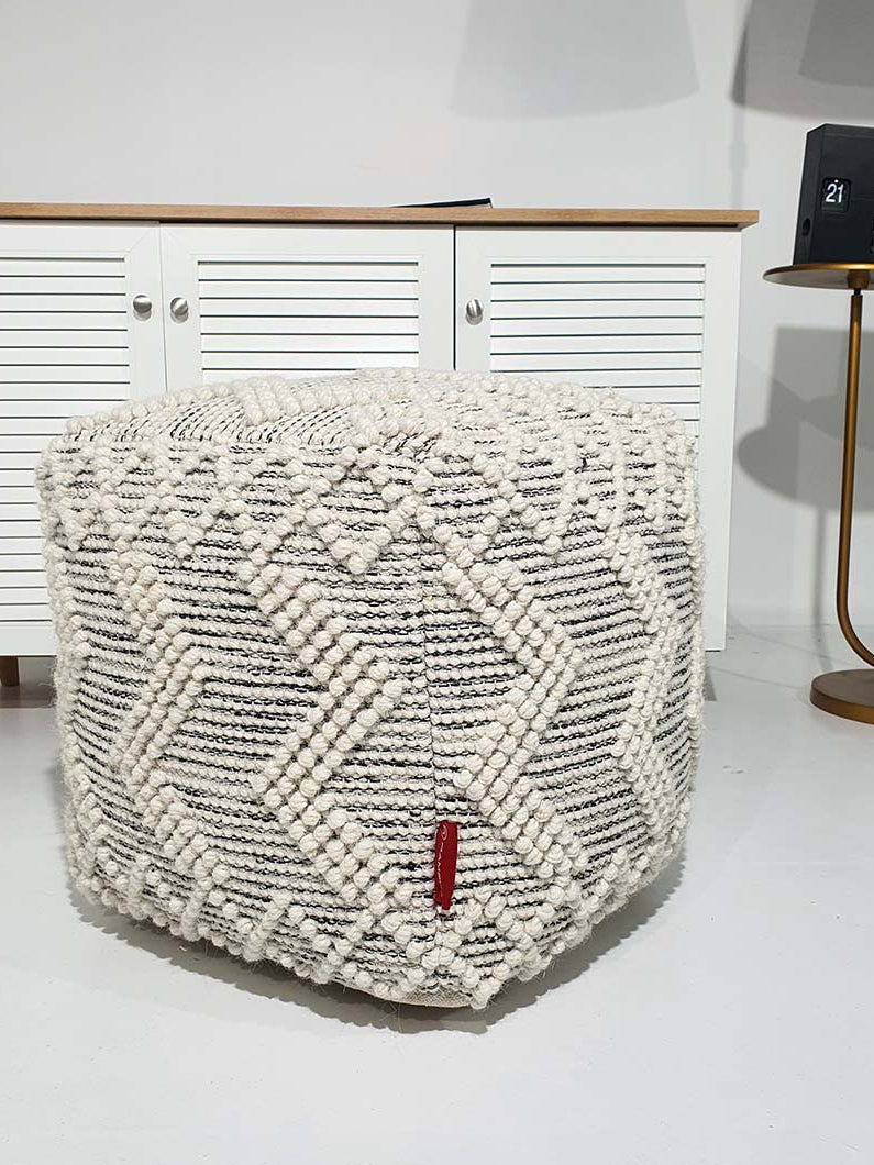Square handmade pouf crafted from 90% wool and 10% cotton with soft natural tones for elegant interiors