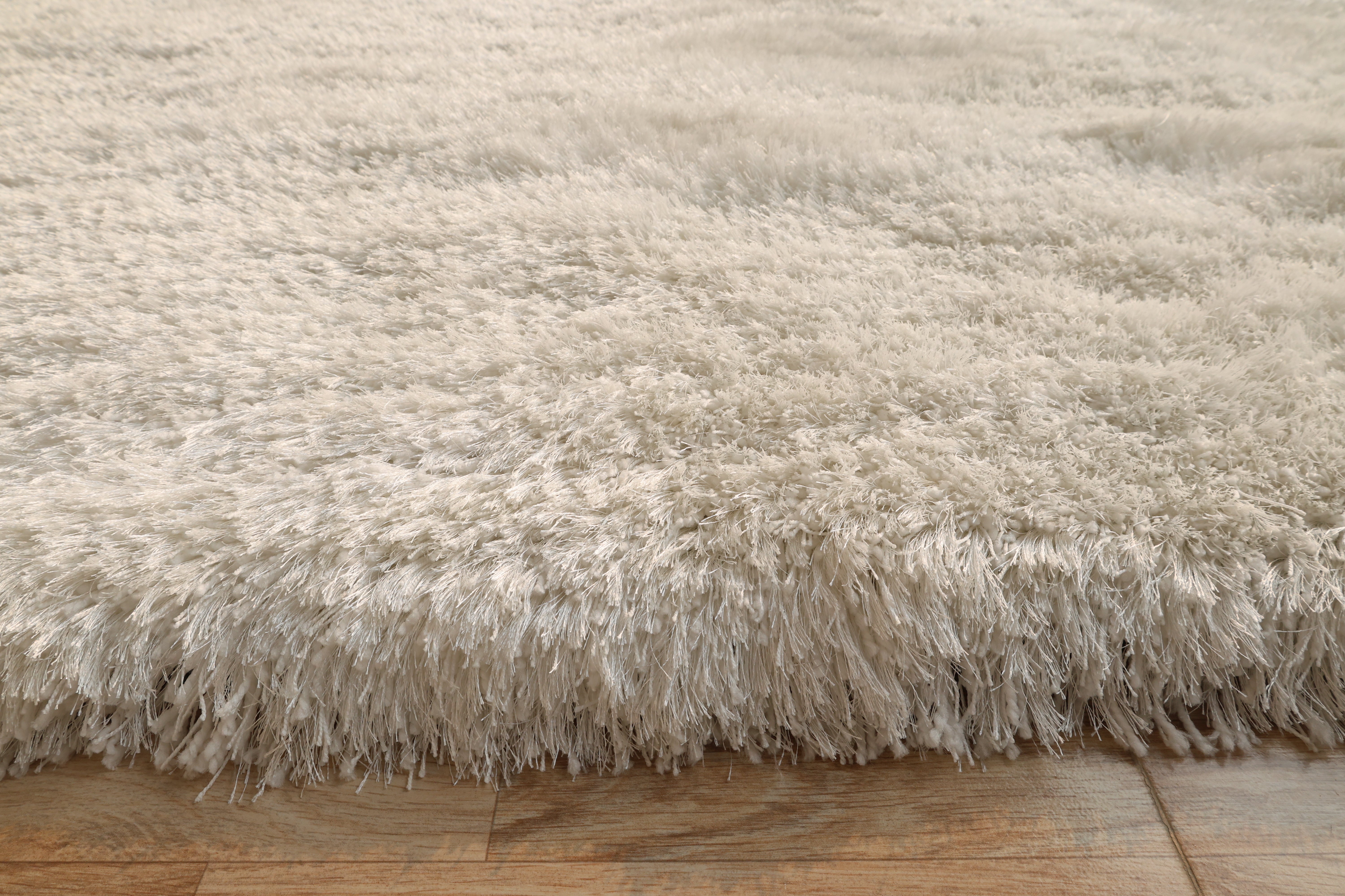Side detailed image of the white rug, confirming the expert craftsmanship and high-quality handmade construction.
