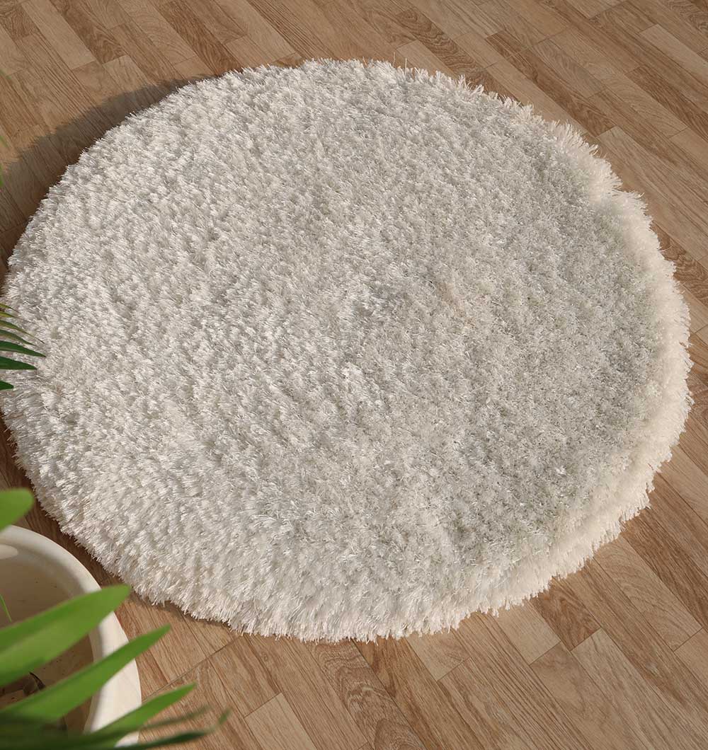 Top-down view of the white round shaggy rug anchoring a living space, adding warmth and plush texture to the home decor.