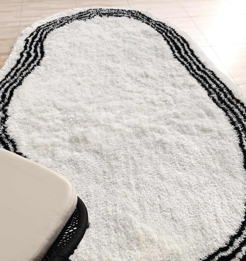 Angled view of the handmade rug, highlighting the durable construction and unique black and white color contrast.