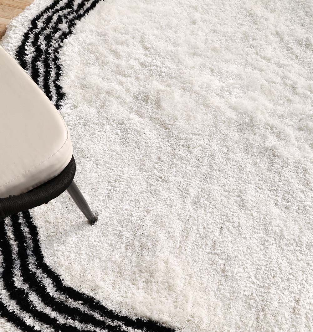 Black and white shaggy rug placed in a living space, adding warmth, comfort, and a touch of sophistication to the room.