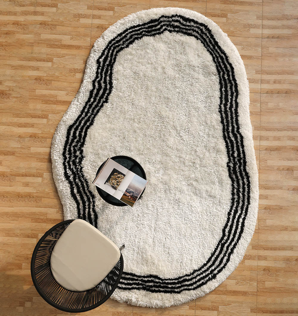 Handmade shaggy rug in black and white irregular shape, offering comfort and plush texture for the floor.