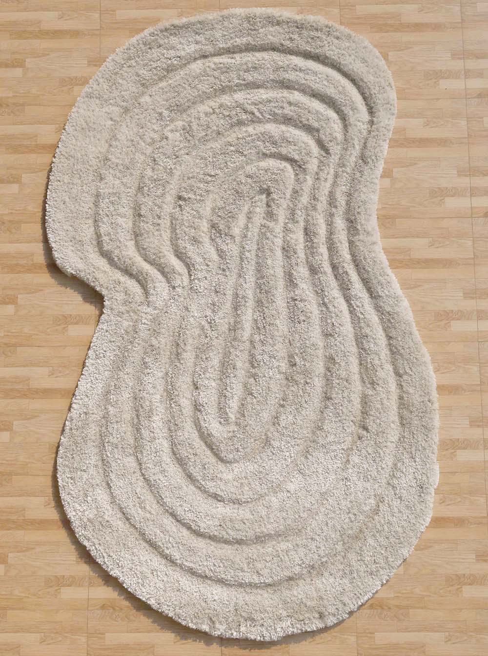 Beige spiral shape shaggy rug, featuring an irregular design and unique character for a sophisticated home.