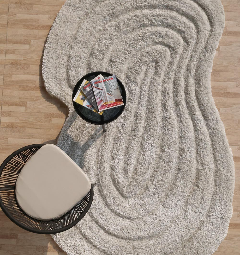 Top-down view showcasing the full irregular spiral shape and comforting beige color of the high-quality area rug.