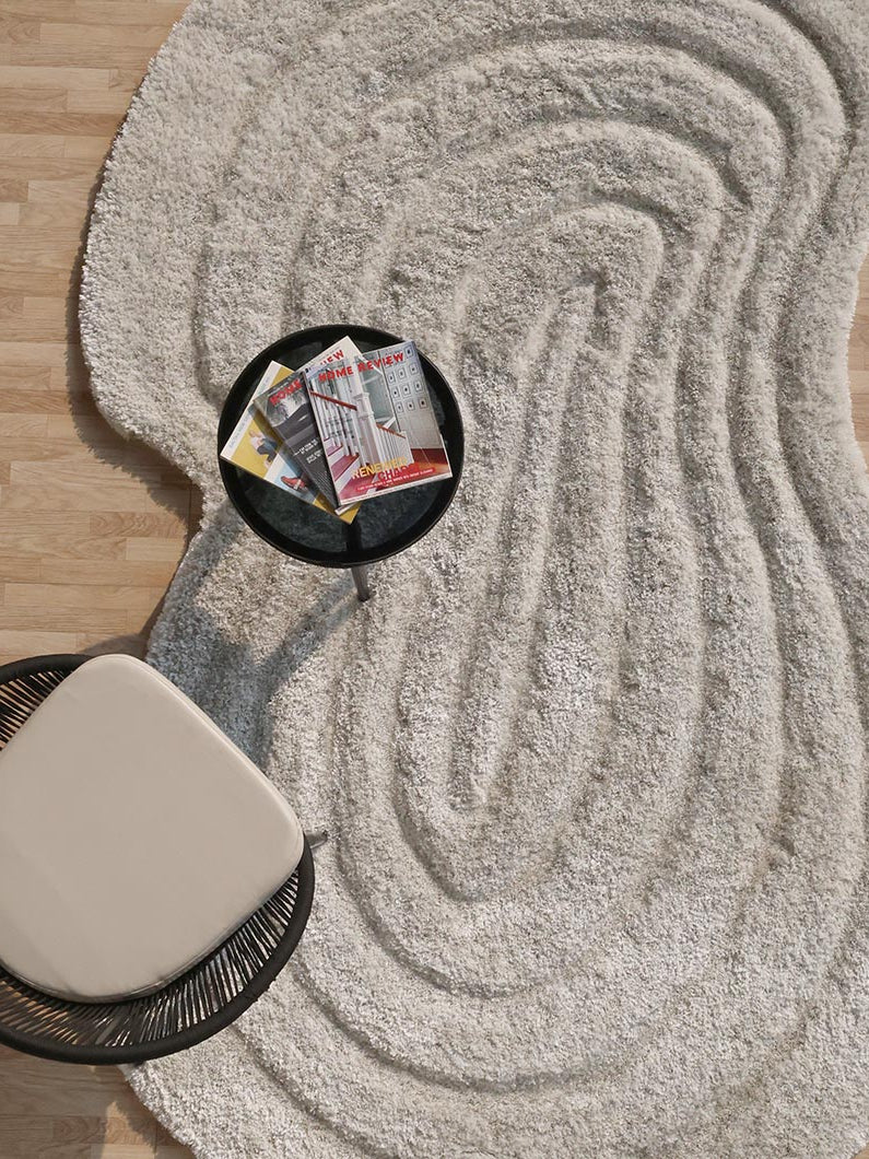 Top-down view showcasing the full irregular spiral shape and comforting beige color of the high-quality area rug.