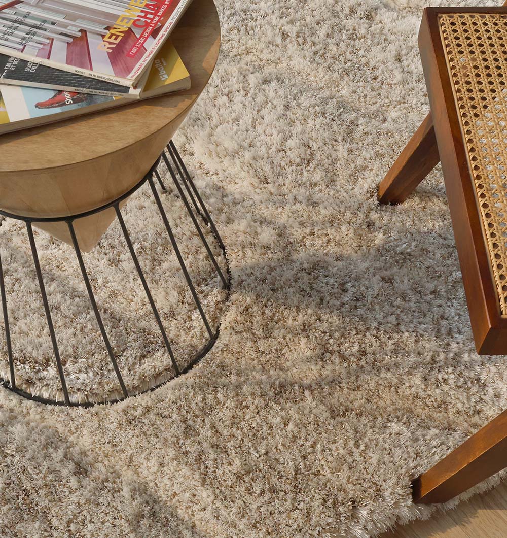 Close-up of the beige spiral-shaped rug next to a decorative element, showcasing its sophisticated design and superior softness.