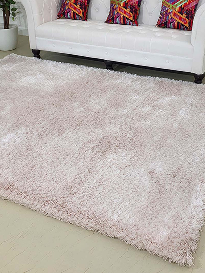 Rectangular natural beige shaggy rug in a living space, showcasing its warm neutral hue and thick profile.