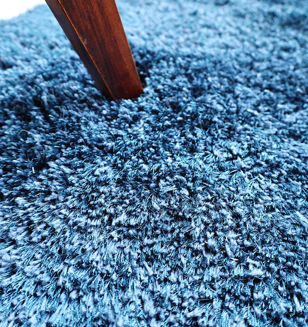 Detailed shot of the blue shaggy pile, highlighting the expert craftsmanship and durability of the unique irregular rug.